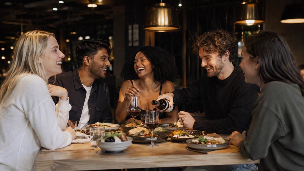 Friends sharing dinner and wine at a restaurant